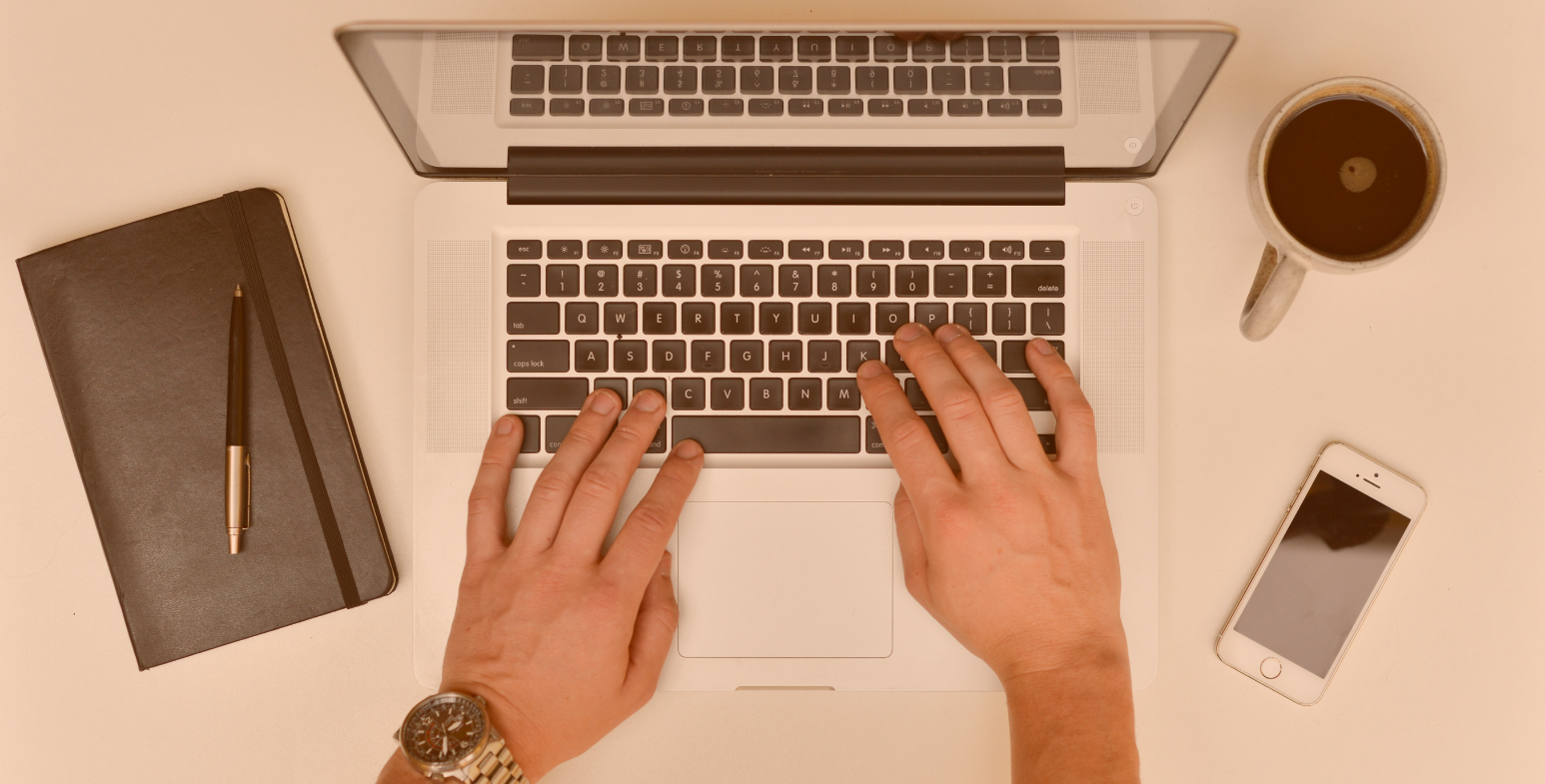 męskie dłonie piszące na laptopie