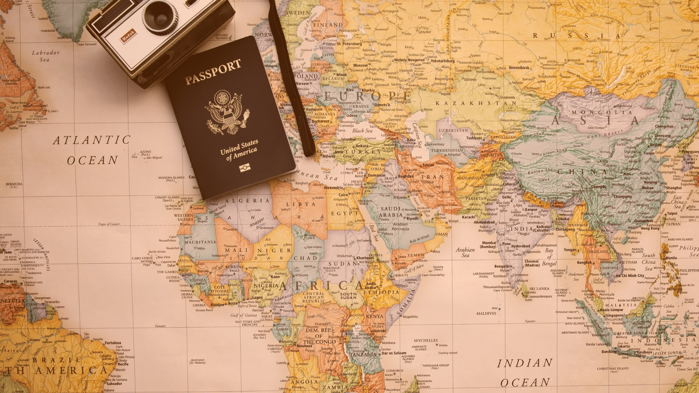 Mapa świata, paszport i aparat fotograficzny.