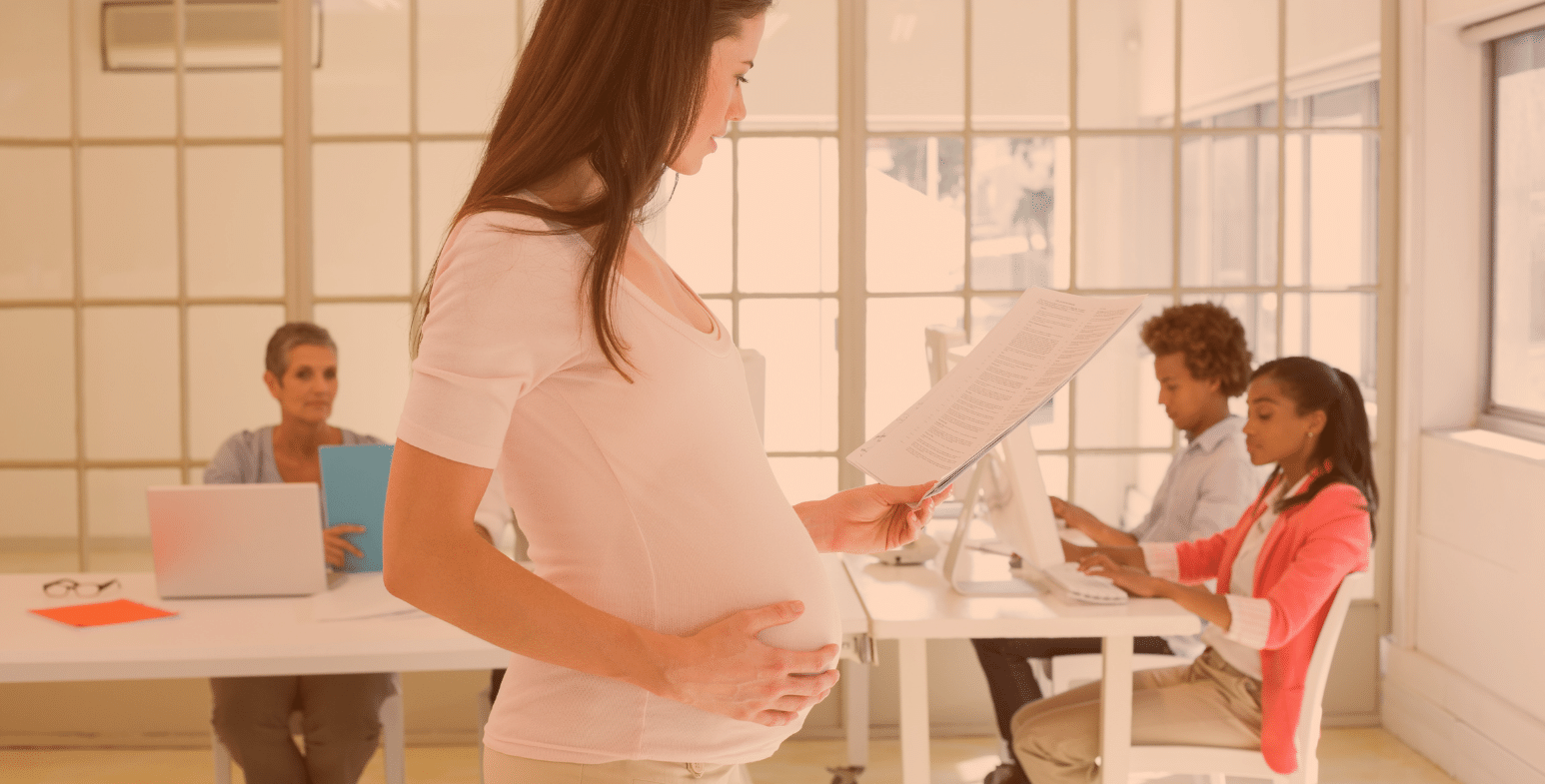 Kobieta w ciąży czytająca dokument.