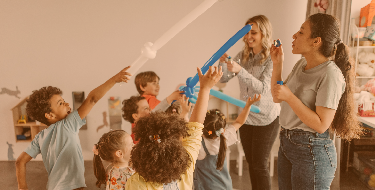 Wychowawcy domu dziecka bawią się z dziećmi mieczami z balonów