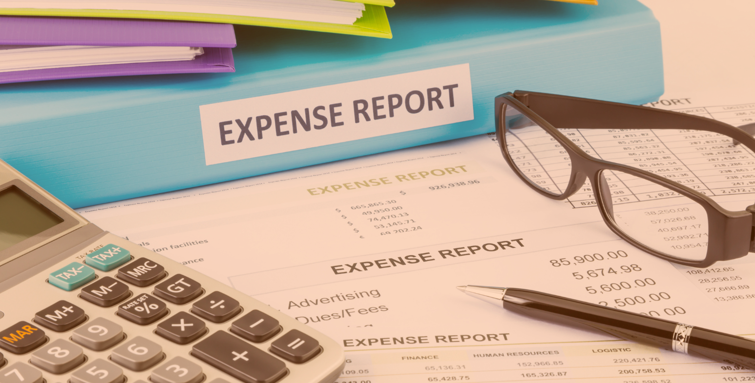 Raport wydatków, okulary oraz kalkulator leżące na dokumentach.